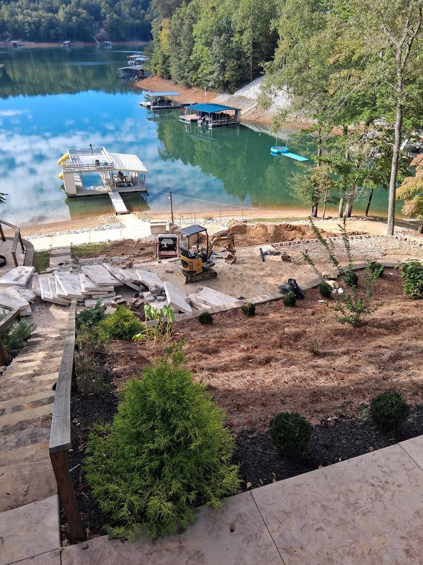 Mini excavator and finished stone patio during a lakefront landscaping project in Campbell County, TN