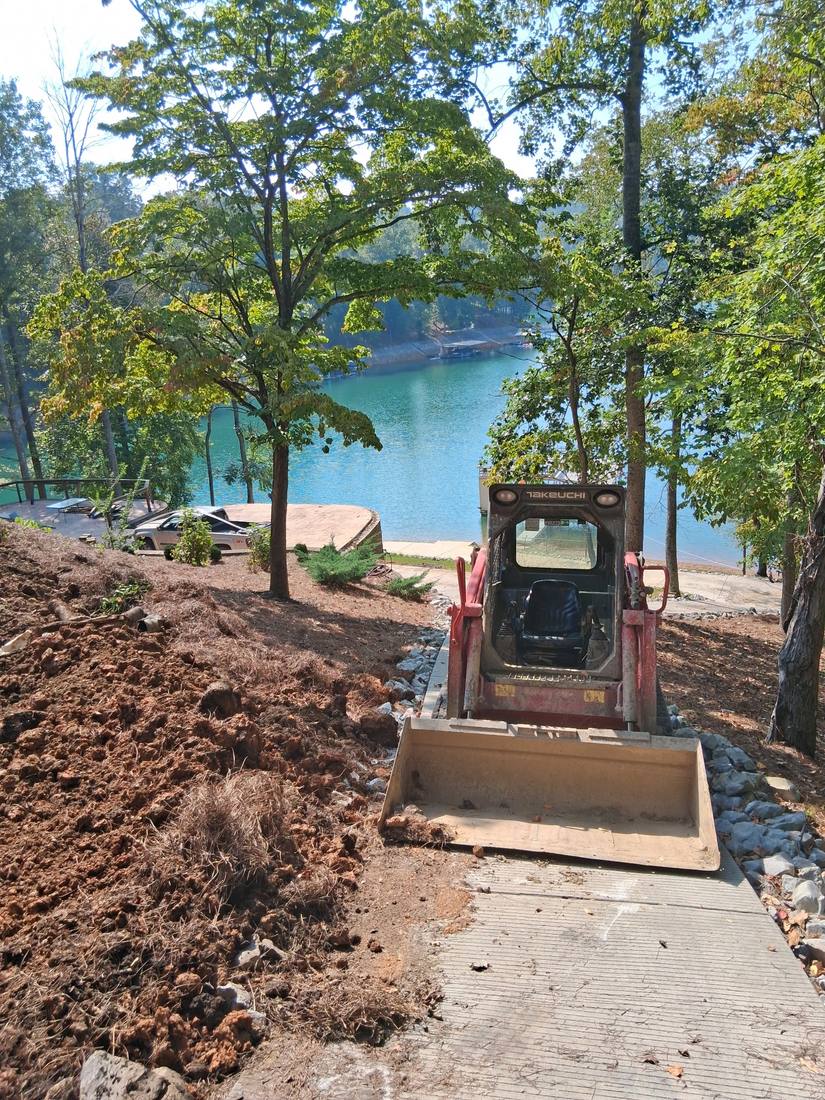 Skid steer excavating soil for a lakefront landscaping project in Campbell County, TN